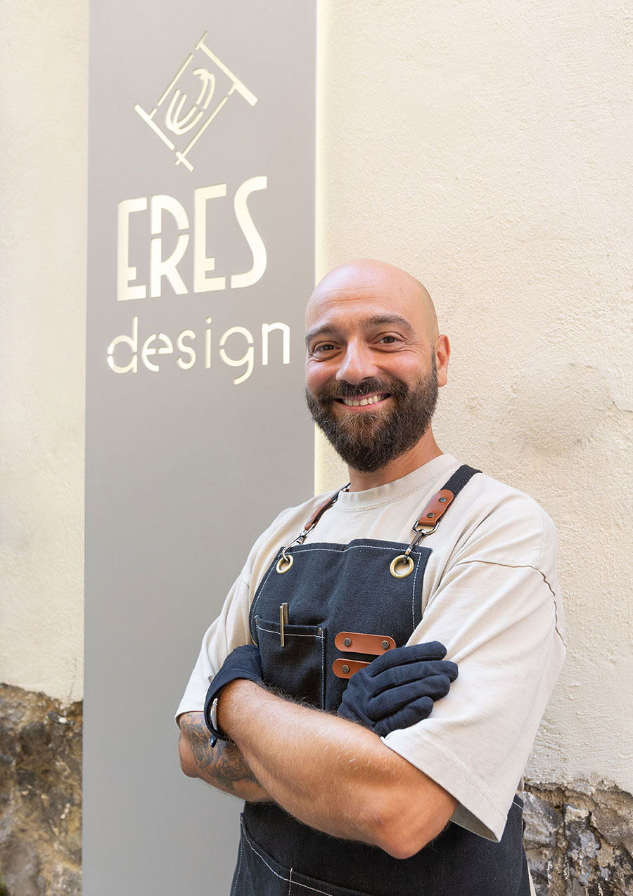 Flavio Toro, fondatore di Eres Design, sorridente davanti all&rsquo;insegna della gioielleria a Napoli